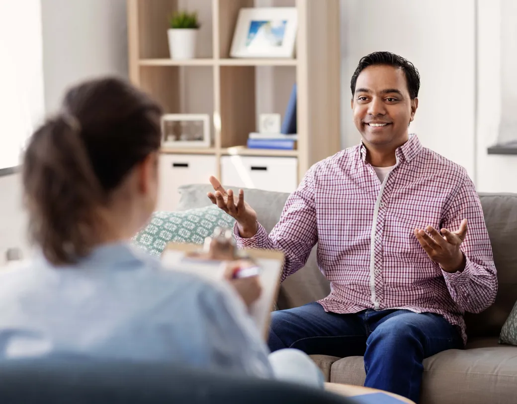 Happy smiling patient and psychologist at psychotherapy session.