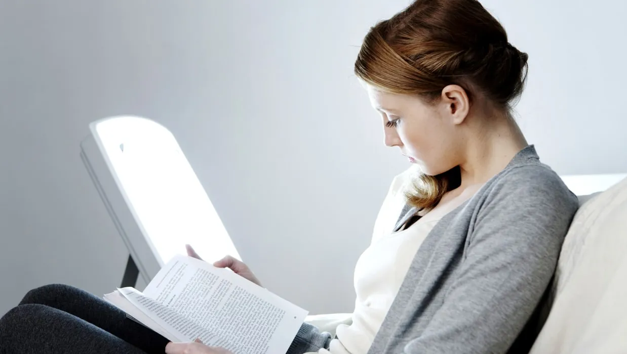 Woman reading in front of a light box