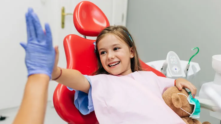 Kid high fiving dentist